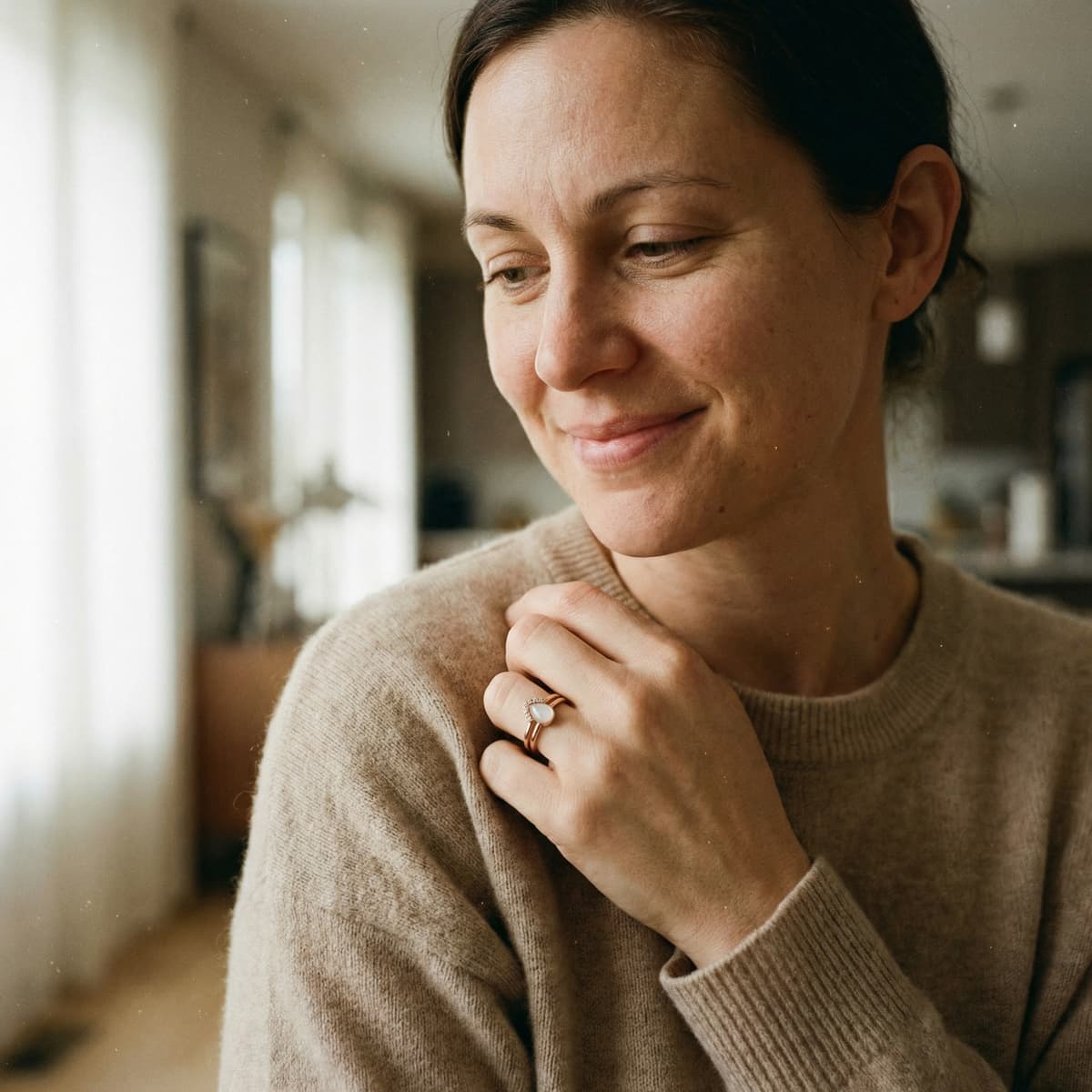 Smiling mother in a cozy home wearing a delicate keepsake ring, showing why a breastmilk ring kit is a meaningful at-home choice for creating a personal memory in private.