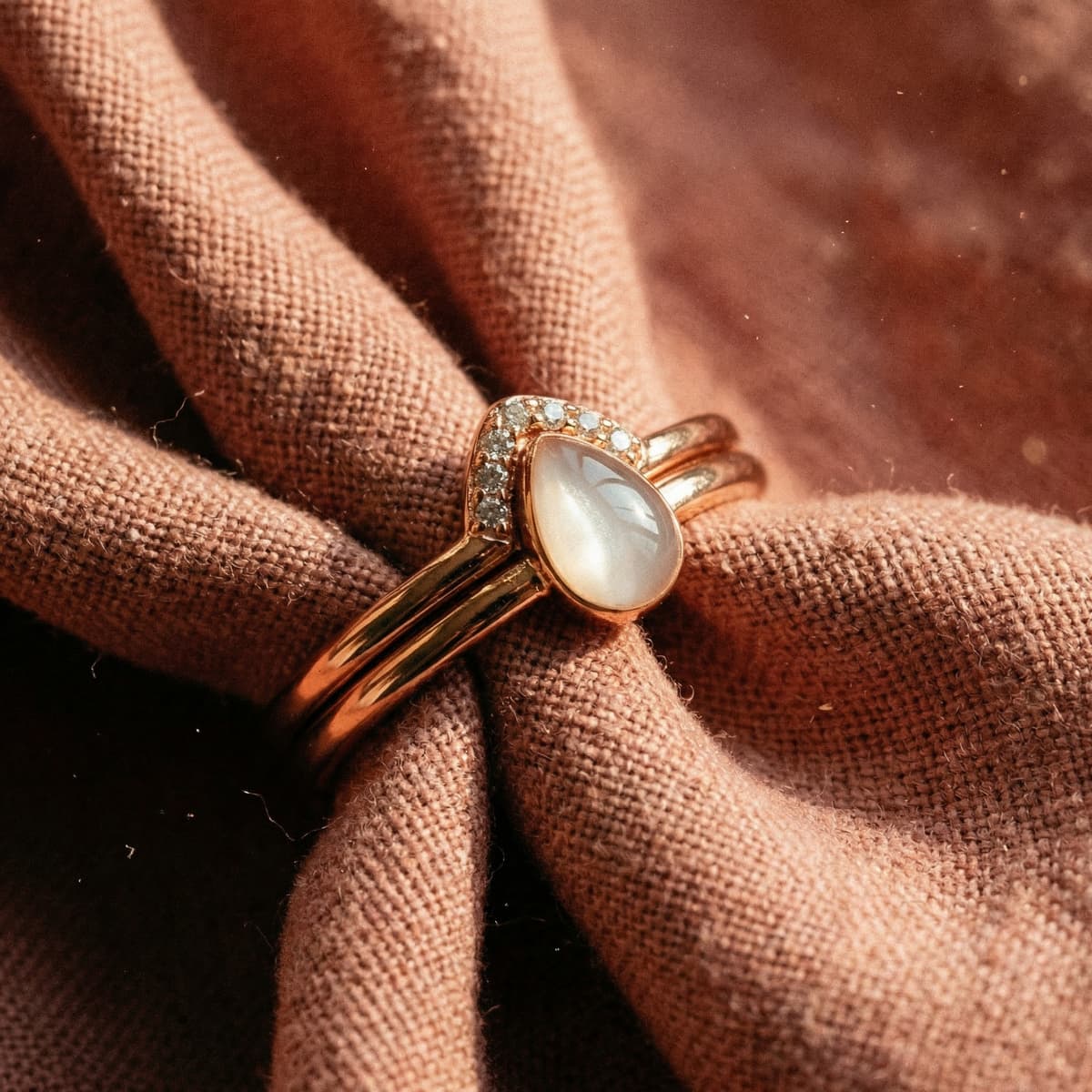 Rose-gold keepsake ring featuring a milky teardrop resin breastmilk stone with a diamond halo, finished result from a diy breastmilk ring kit displayed on soft fabric.